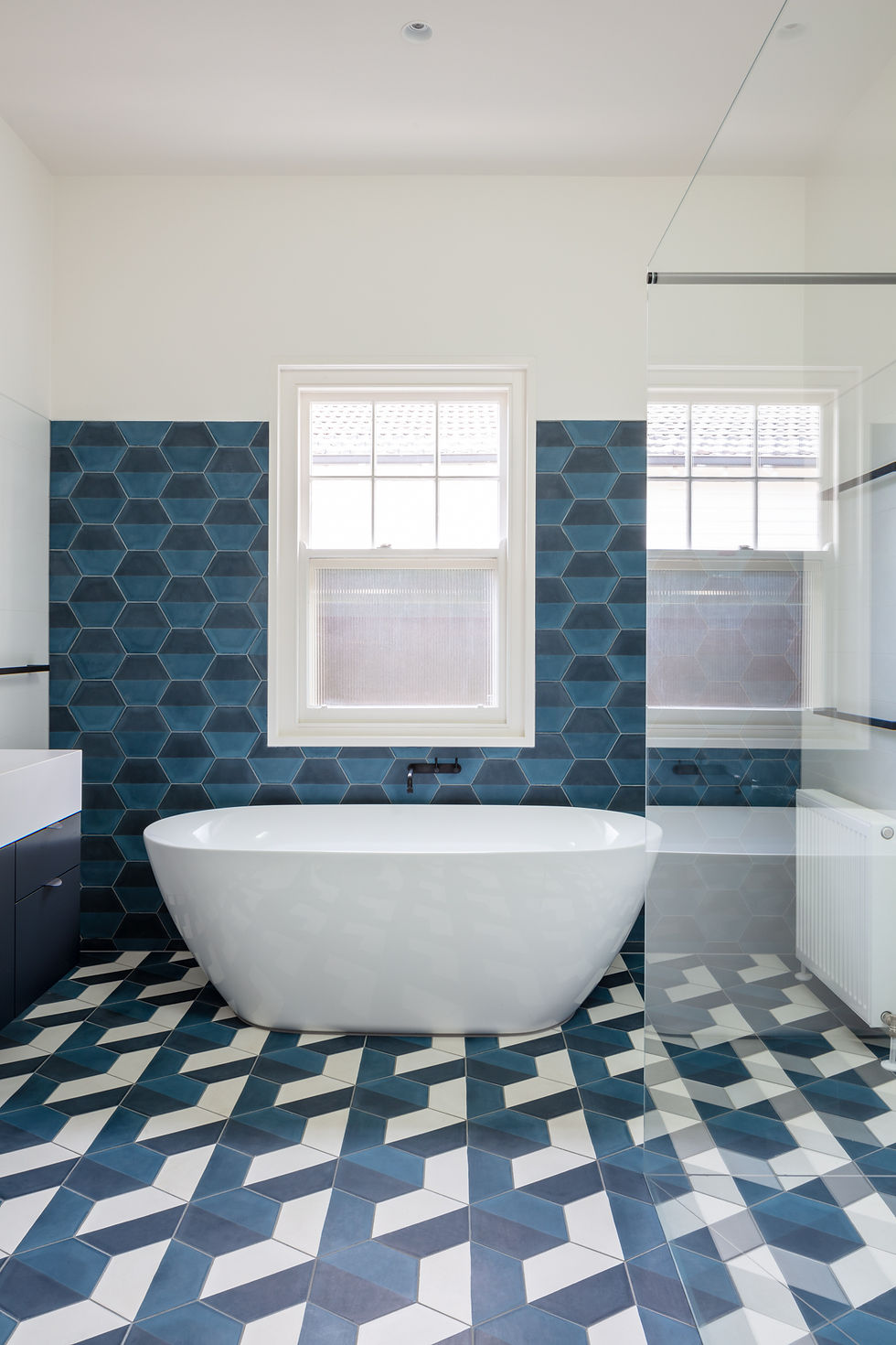 The bathroom of our Sandy Bay house is a luxurious retreat with its sapphire blue geometric tiles.