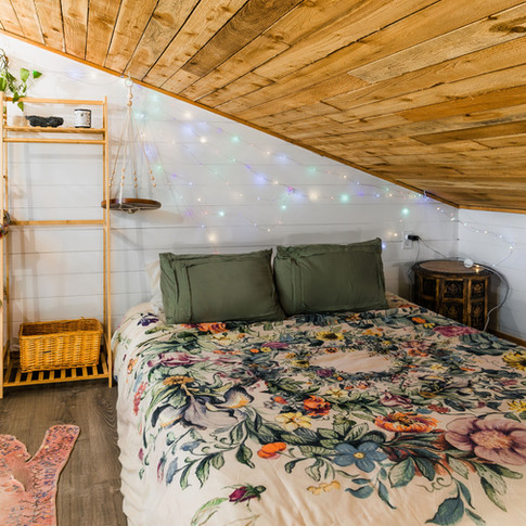 Loft bedroom with vibrant wood interior and cozy bed in Hidden Valley Treetop Cabin