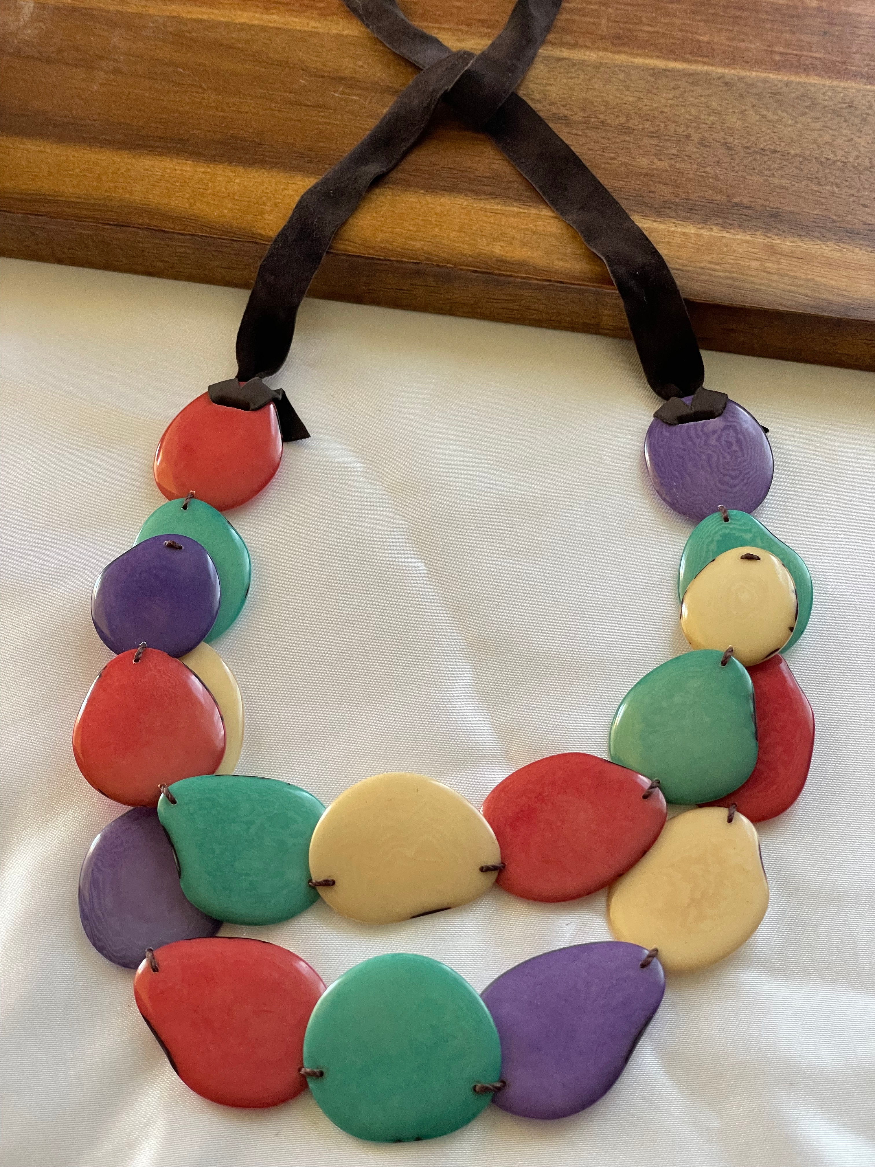 Tagua bib necklace, featuring 18 individually shaped chips in turquoise, yellow, gray, and orange.