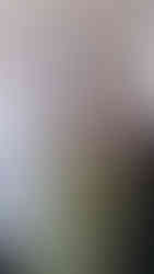 mąż wiesza obrazki w ramkach w sypialni 