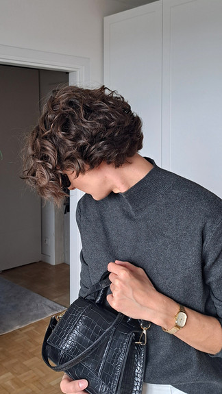 dziewczyna w białych spodniach i szarym swetrze z golfem