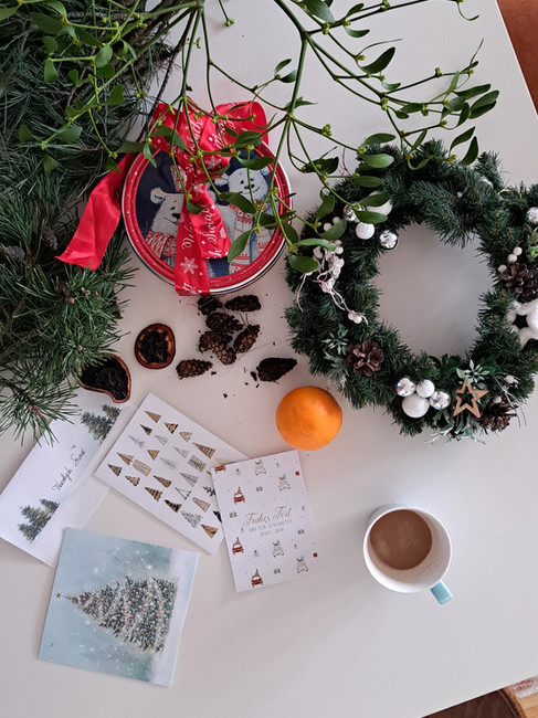 świąteczne dekoracje DIY na białym stole, jemioła, szyszki, pomarańcze