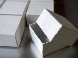 A custom-made box made from simple white washi paper with a distinctive embossed lid on the top.