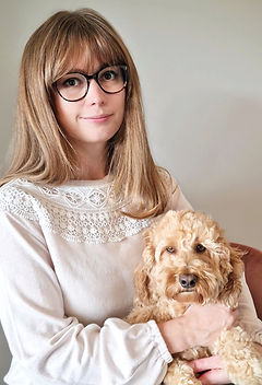 Portrait artist with her cockapoo dog. The artist specializes in custom oil pet portraits with expressive brushwork.