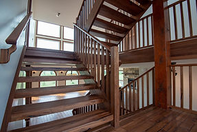 Custom open rise stairs in Medieval Walnut with wood spindles.