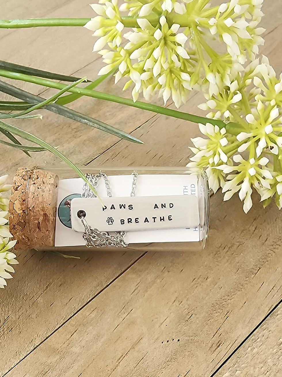 Thumbnail: "Paws and breathe" bar necklace is packaged in a clear glass vial