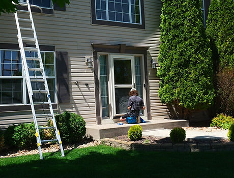 Glass House owner Carson Brenny at the front entry of a home with his ladder set up