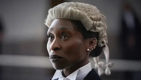 Behind the scenes still from a film drama production showing camera crew and lead actors on set. Cynthia Erivo