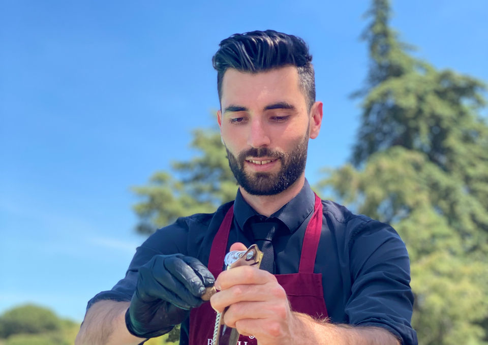 Professional bartender preparing multiple cocktails outdoors.