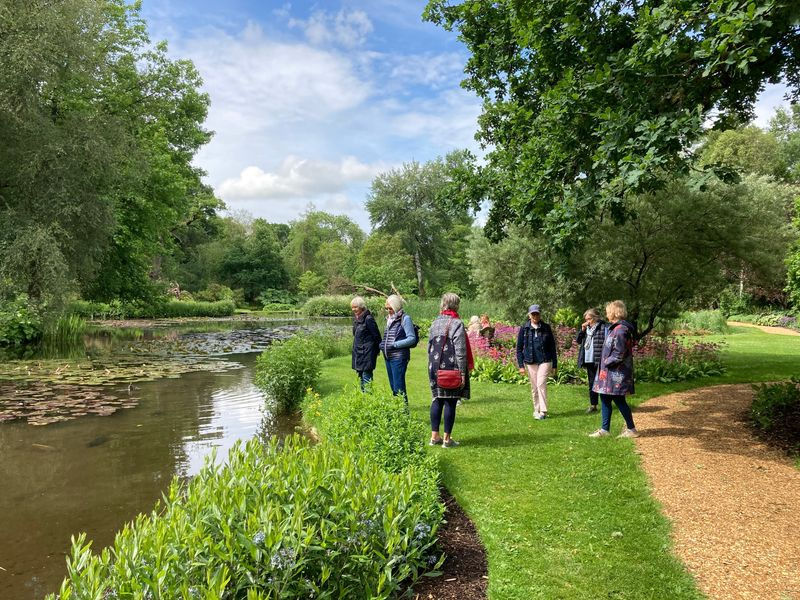 People standing next to one of the lakes in the Longstock water gardens