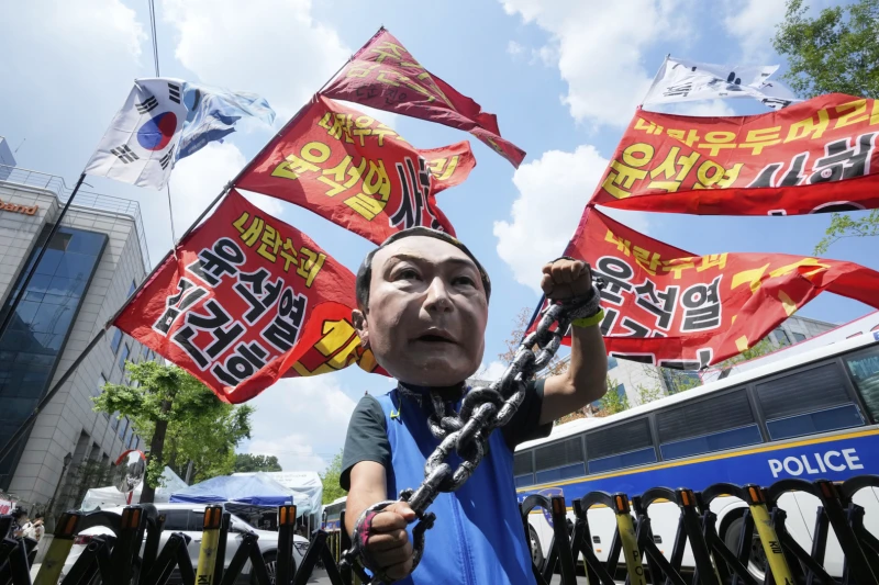 A protester wearing a mask of former South Korean President Yoon Seok-yeol attends a rally in support of a hearing to review a special prosecutor's application to arrest Yoon near the Seoul Central District Court in Seoul, South Korea, Wednesday, July 9, 2025. The mask reads "Yoon Seok-yeol Sentenced to Death." (AP/Ahn Young-jun)