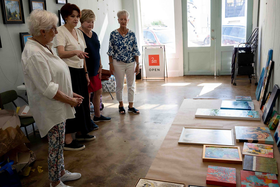 Kimberly Crawford and the Art Group THREE deciding which art should be hung at 2tiny gallery.