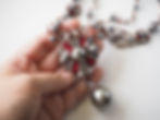 Thumbnail: hand holding necklace for size comparison