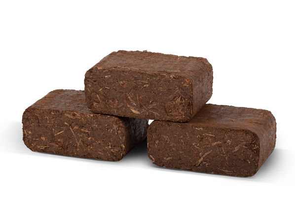 Three bark briquettes stacked in a pyramid shape.