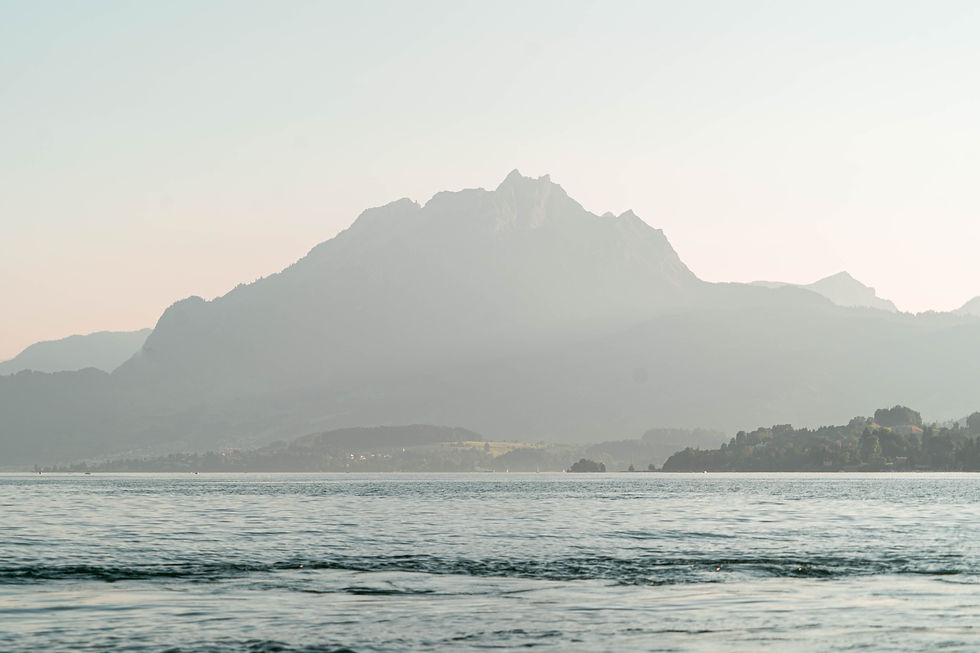 Blick über einen See in der Schweiz, im Hintergrund Alpenpanorama.
