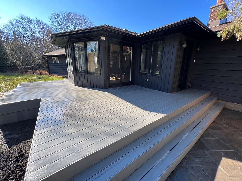 Wide composite deck extending from house, spacious and functional for gatherings.