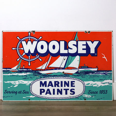 Reverse side of Woolsey Marine Paints porcelain sign with enamel chipping around the top mounting holes
