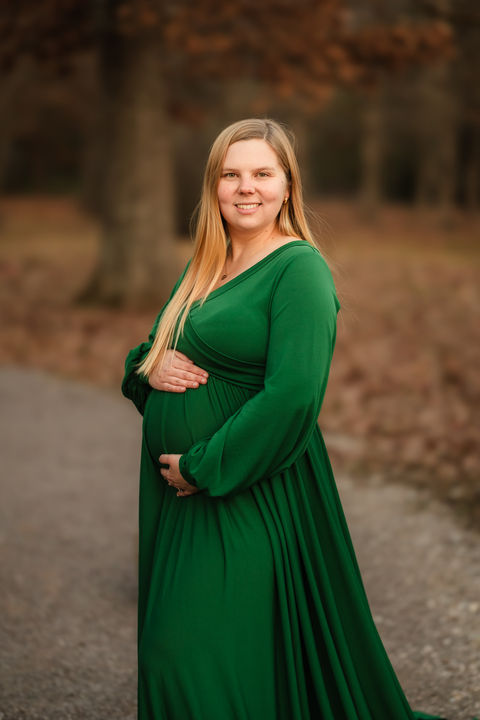 fall maternity photo of woman in a green maternity dress at knoxville botanical garden / photo by knoxville maternity and newborn photographer wood shutter photography / see more at woodshutterphotography.com