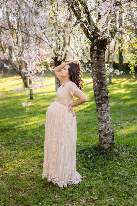 spring maternity photo of woman in a soft pink dress in a cherry blossom glen at knoxville botanical garden / photo by knoxville maternity and newborn photographer wood shutter photography / see more at woodshutterphotography.com