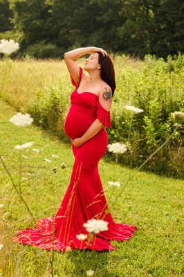 Red maternity gown with off the shoulder ruffle sleeves and a mermaid silhouette. photo by Knoxville maternity, newborn, and family photographer Wood Shutter Photography