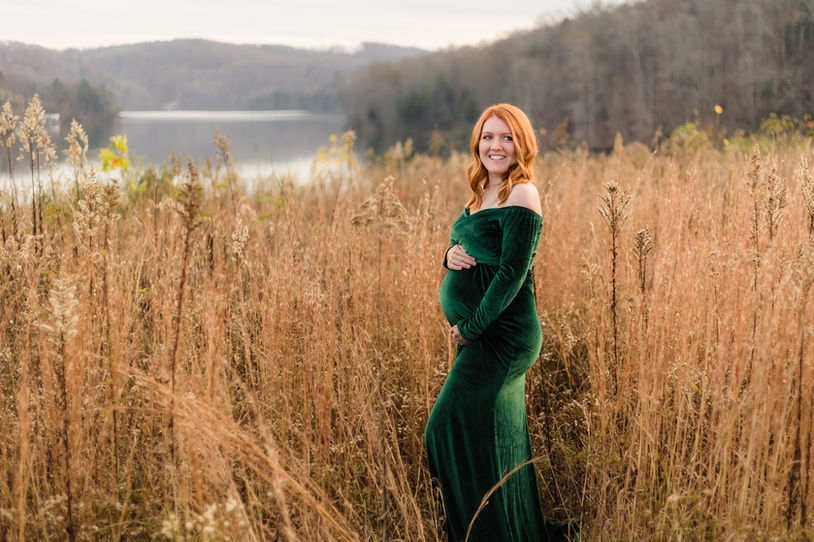 fall maternity photo of woman in a green velvet maternity dress at melton hill park in oak ridge / photo by knoxville maternity and newborn photographer wood shutter photography / see more at woodshutterphotography.com
