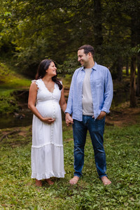 expecting mom and dad holding hands in front of a creek during Knoxville TN maternity portrait session photo by Knoxville maternity, newborn, and family photographer Wood Shutter Photography