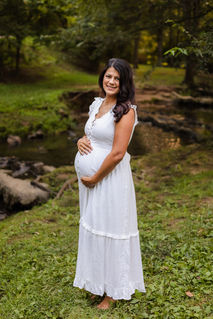 expecting mom in a white cotton dress in front of a river at founders park at campbell station road during Knoxville TN maternity portrait session photo by Knoxville maternity, newborn, and family photographer Wood Shutter Photography