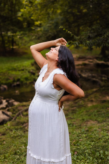 spring summer maternity photo of woman by a creek in a white lace maternity dress at founders park at campbell station in farragut tn / photo by knoxville maternity and newborn photographer wood shutter photography / see more at woodshutterphotography.com