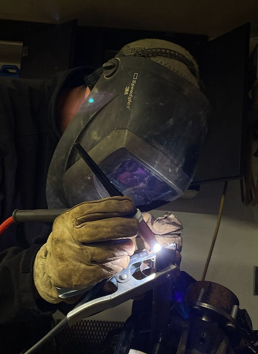 Ken Frazee welding with gloves and a helmet
