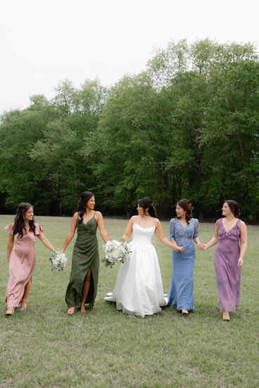 Bride and Bridesmaids Walking Through Field