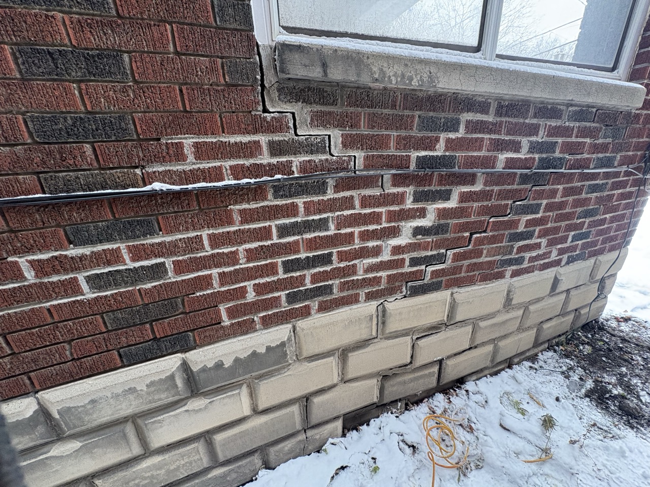 Step cracking through brick due to a sinking foundation.