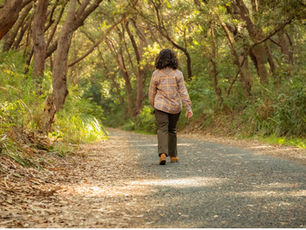Bariatric patient walking down a path alone