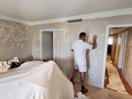 Professional painter painting interior wall of residential home in Western Australia