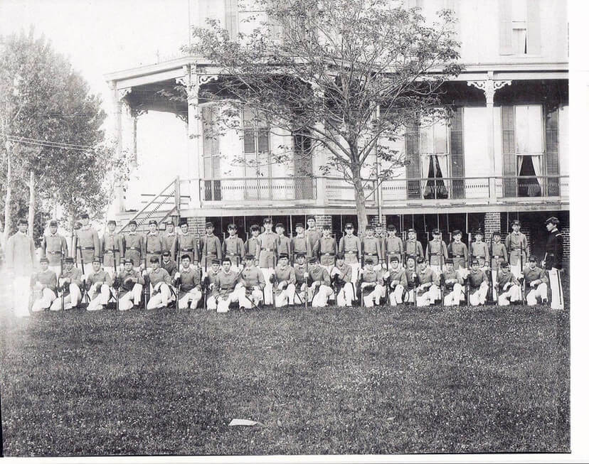 old photograph of soliders in front of a hotel