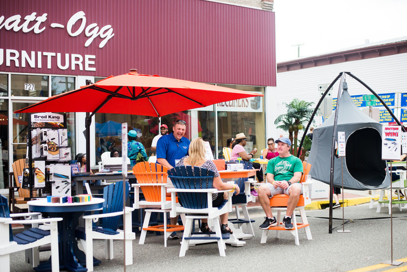 people sitting outside a furniture store