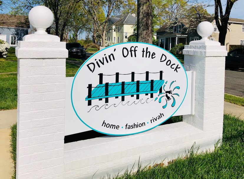 brick sign that says divin off the dock
