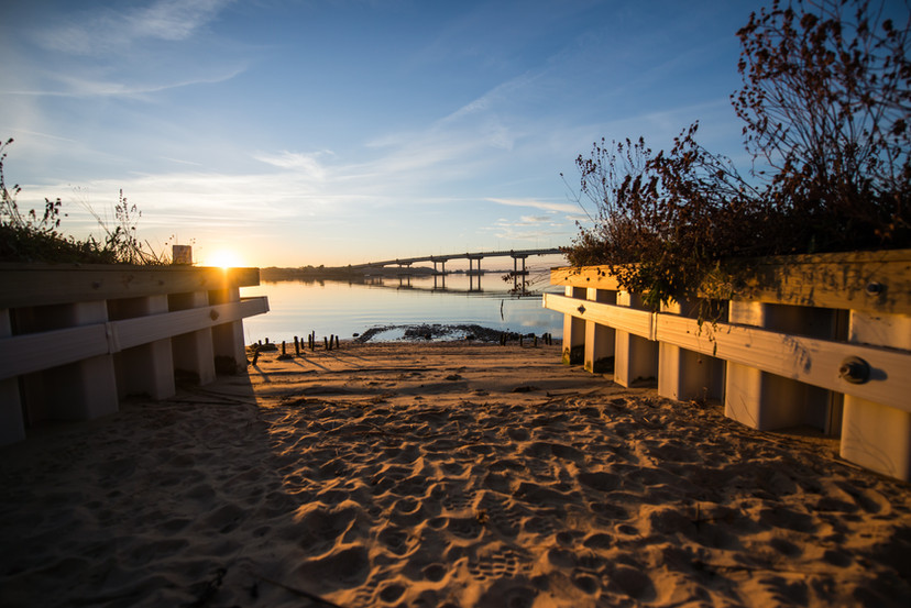 sandy kayak launch with bridge in background