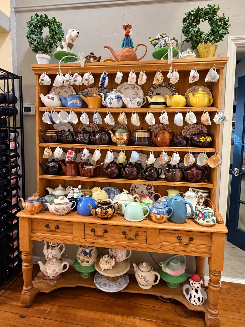 Collection of colorful teapots and hanging teacups displayed inside The BonBonerie Café
