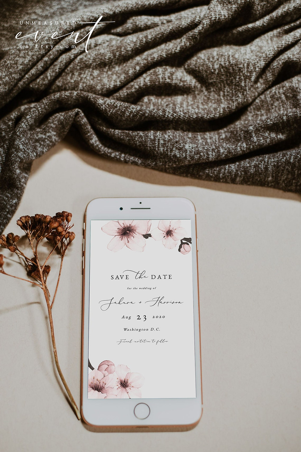 HARMUI Collection virtual save the date that shows watercolor cherry blossoms and an edgy font all displayed on a cell phone. a leaf and gray blanket can be seen in the background. All via unmeasured events.