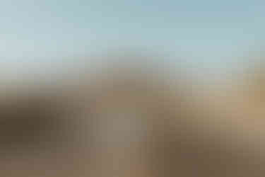 bride and groom dancing in their boho wedding attire in the middle of the street. the desert can be seen in the background. All via Unmeasured Events