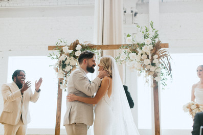 bride and groom about to kiss as they smile at one another up at their wedding alter. all via unmeasured events