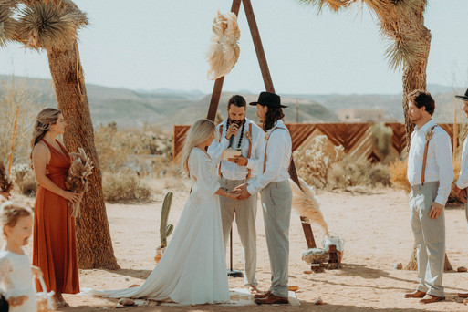 bride and groom during their wedding ceremony at their boho alter with the desert in the background. All via Unmeasured Events