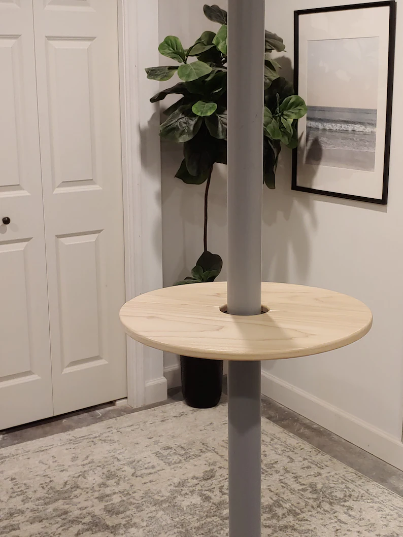 photo of a bar pole tray table attached and inserted to a a basement pole. The tray is circular shaped and made of wood