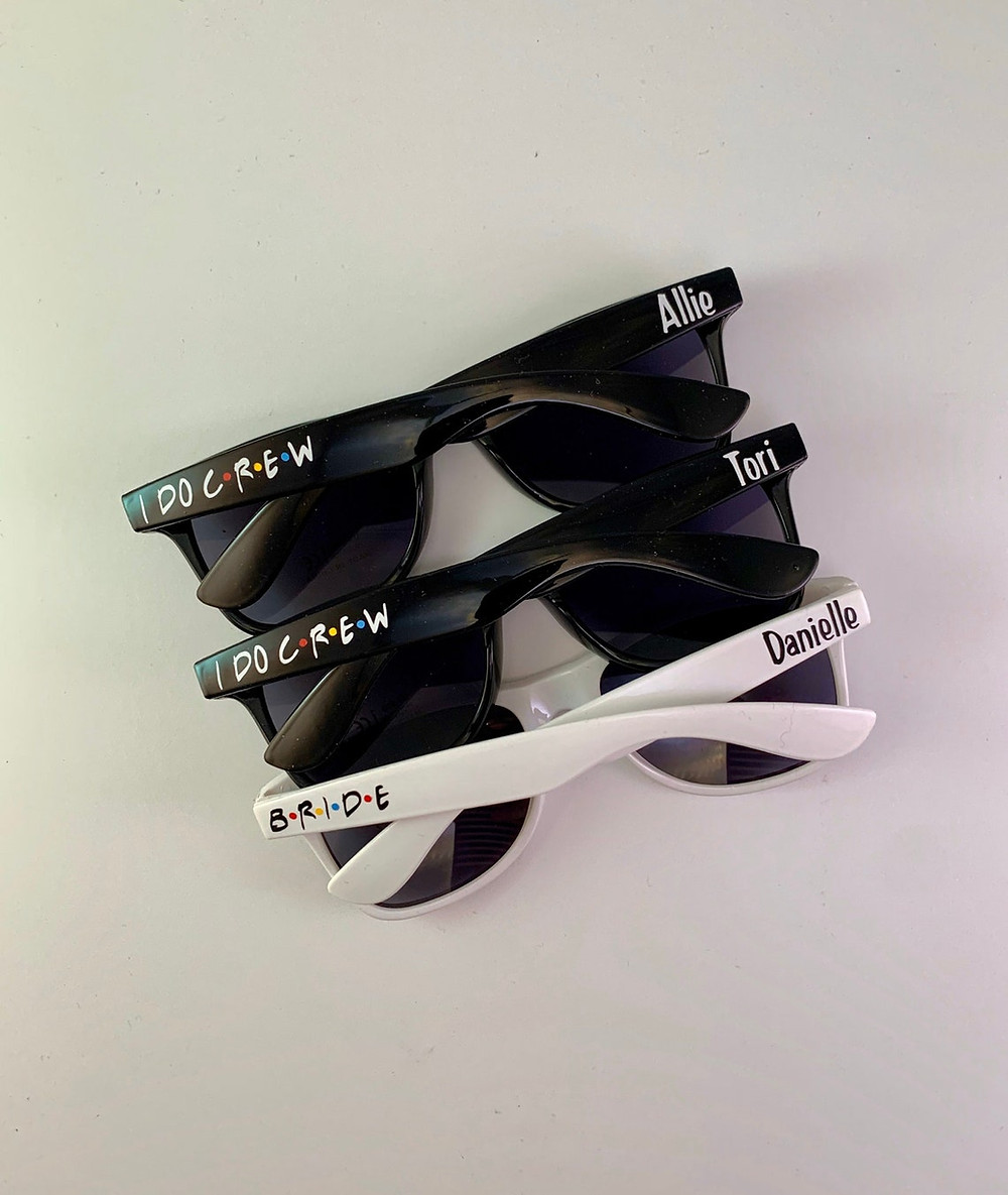 photo of three pairs of plastic sunglasses with "friends" themed writing on the sides. two of the sunglasses are black and one is white. They are on a white background. All Via Unmeasured Events