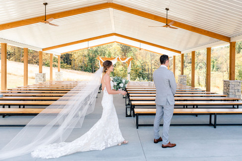 bride about to surprise her groom for their first look outside in a seating area. All via Unmeasured Events