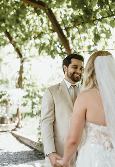 bride and groom smiling at one another during their first look. all via unmeasured events