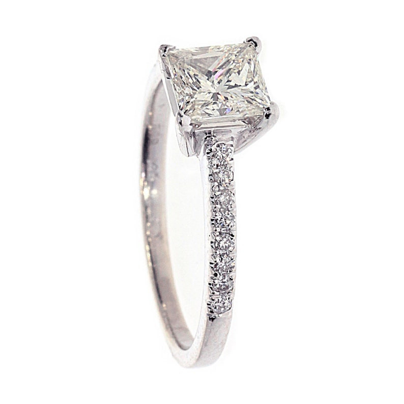 Photo of a side view of a princess cut and pave diamond ring set in a white gold band