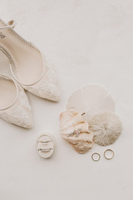 Beautiful lace bridal shoes, bridal accessories, and sea shells in West Palm Beach Florida flatlay
