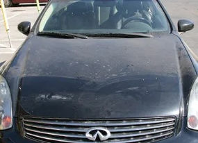 Front view of black Infiniti car showing the logo on the hood.