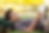 Teen lying on grass, reading a book, backpack as pillow. Sunny day, blurred green and yellow background, relaxed and peaceful mood.